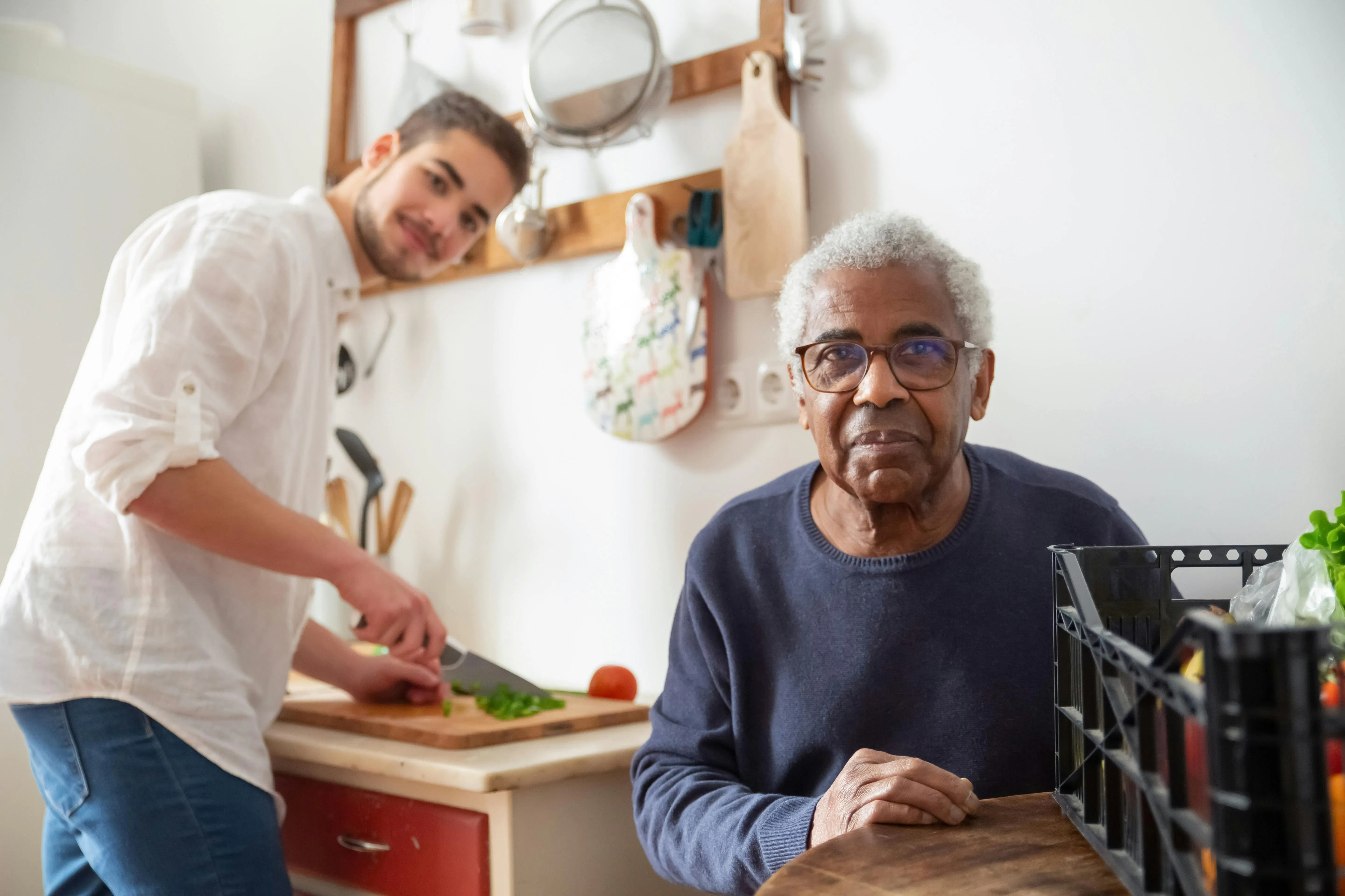 An elderly man sitting while wearing eyeglasses