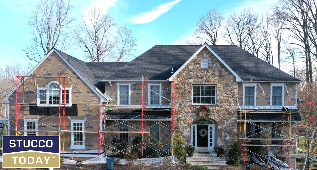 large suburban house with stucco remediation in progress