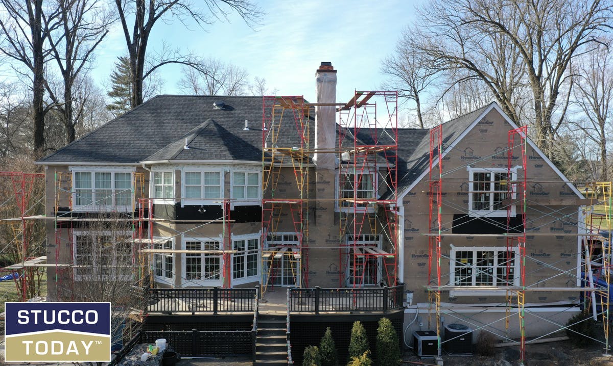 large suburban house with stucco remediation in progress