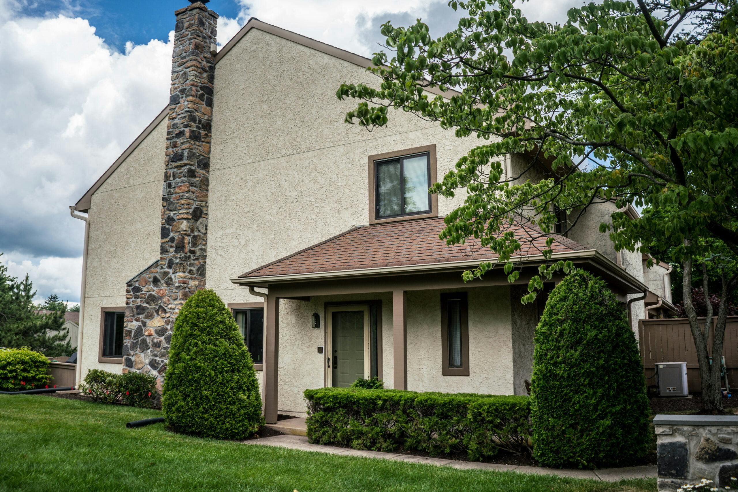 home with stucco and stone chimney