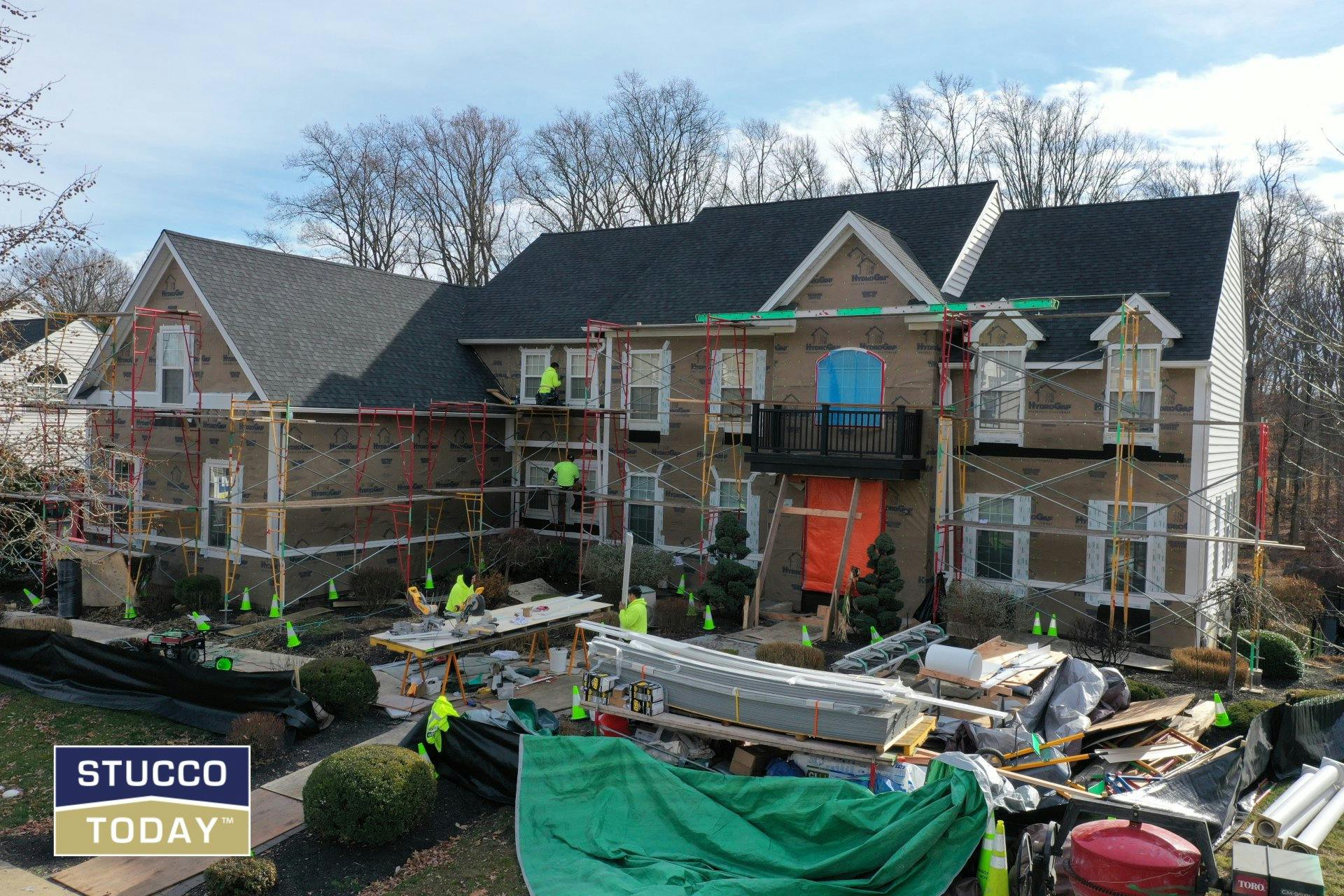 workers on scaffolding in stucco remediation process