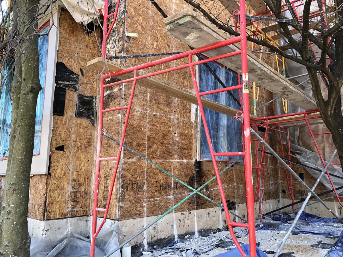 two story suburban house with in progress stucco remediation