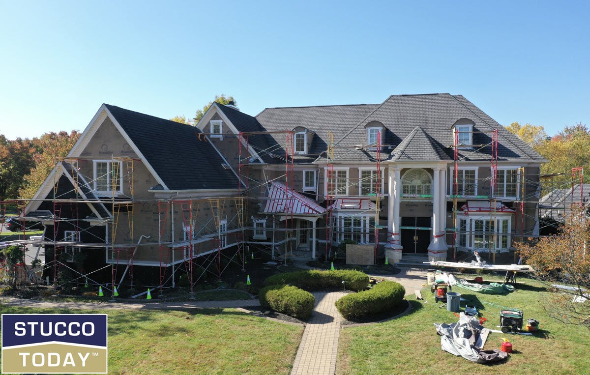 large suburban house with stucco remediation in progress