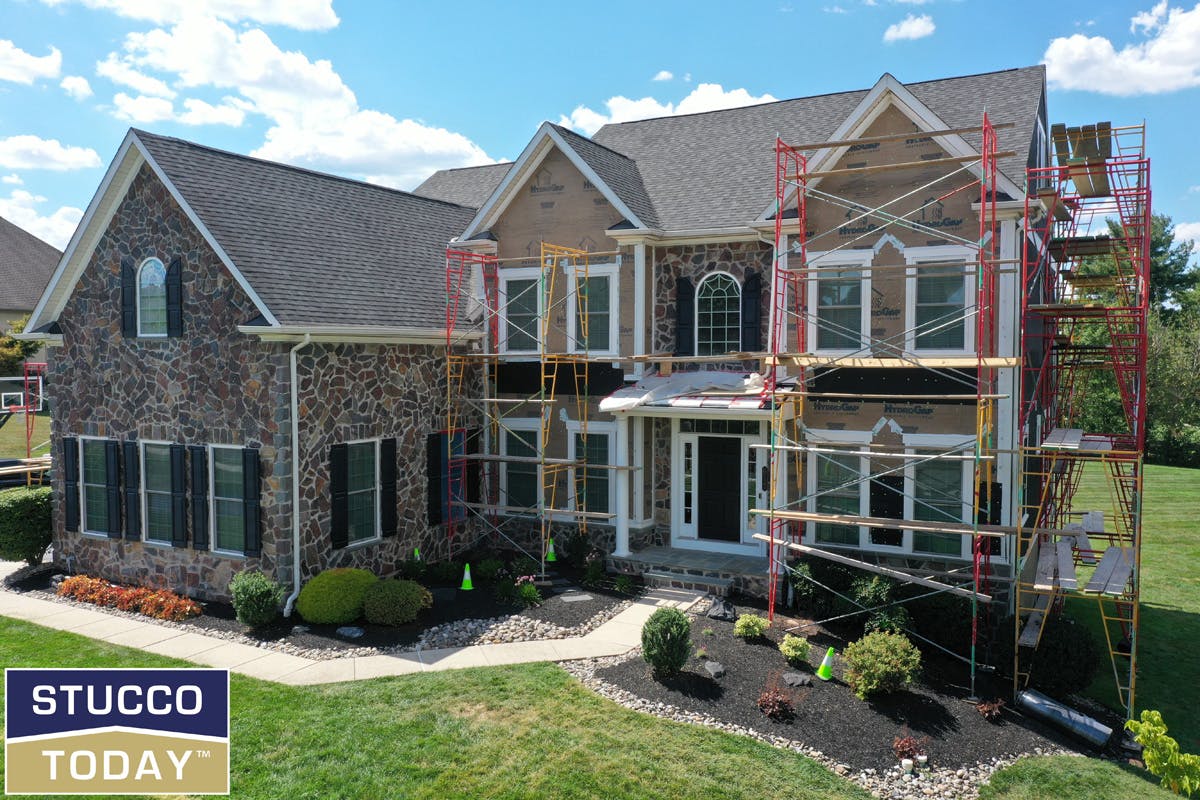 large suburban house with stucco remediation in progress