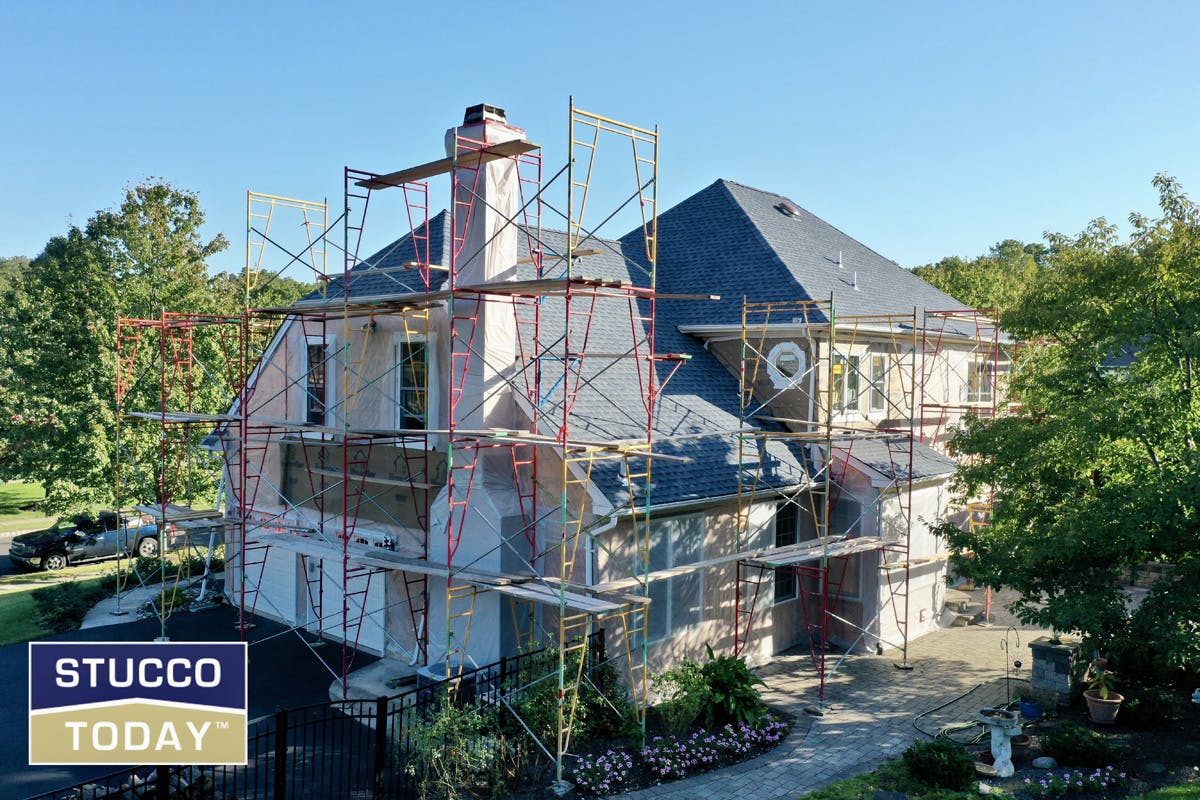 large suburban house with stucco remediation in progress