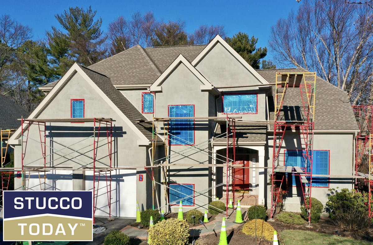 large suburban house with stucco remediation in progress