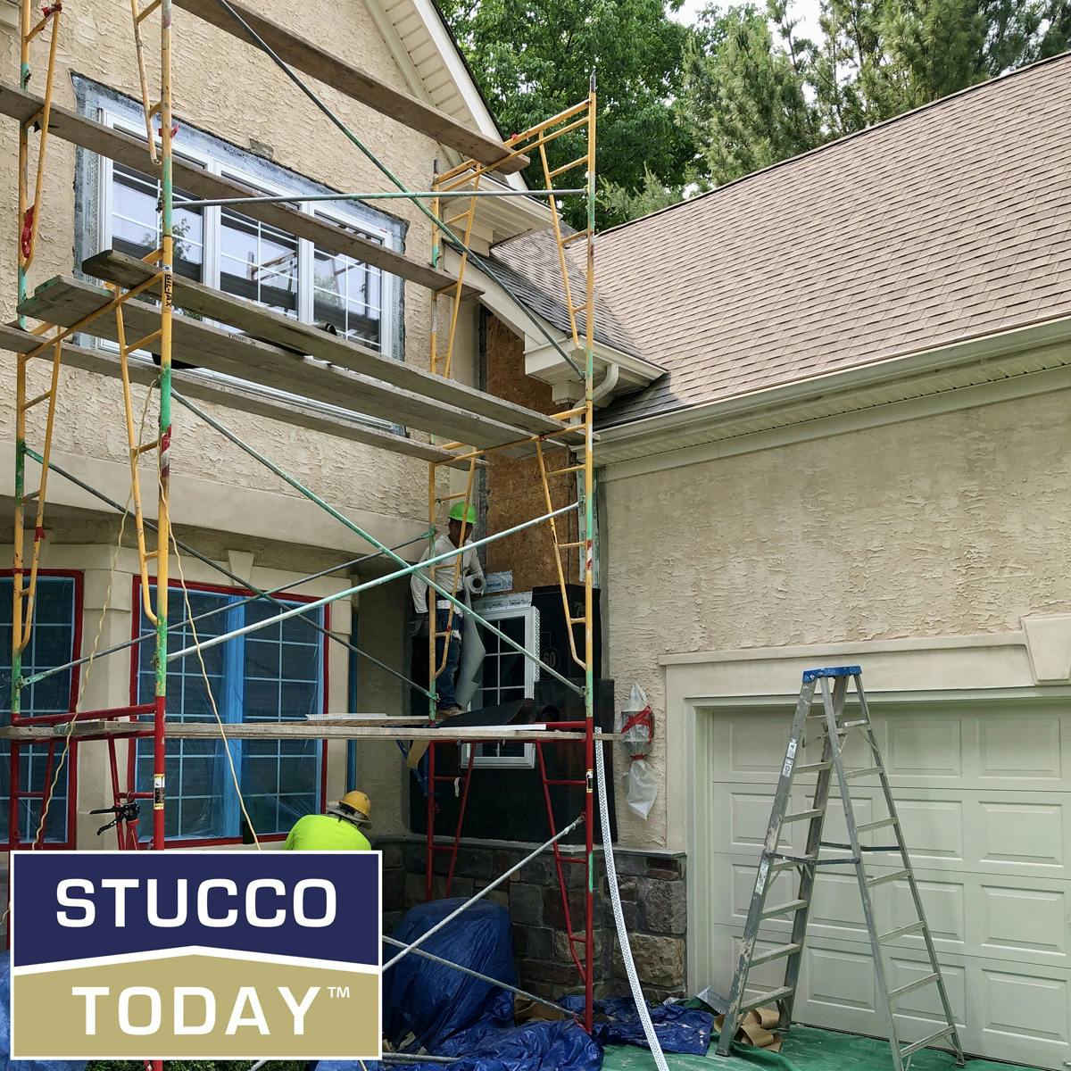 large suburban house with stucco remediation in progress