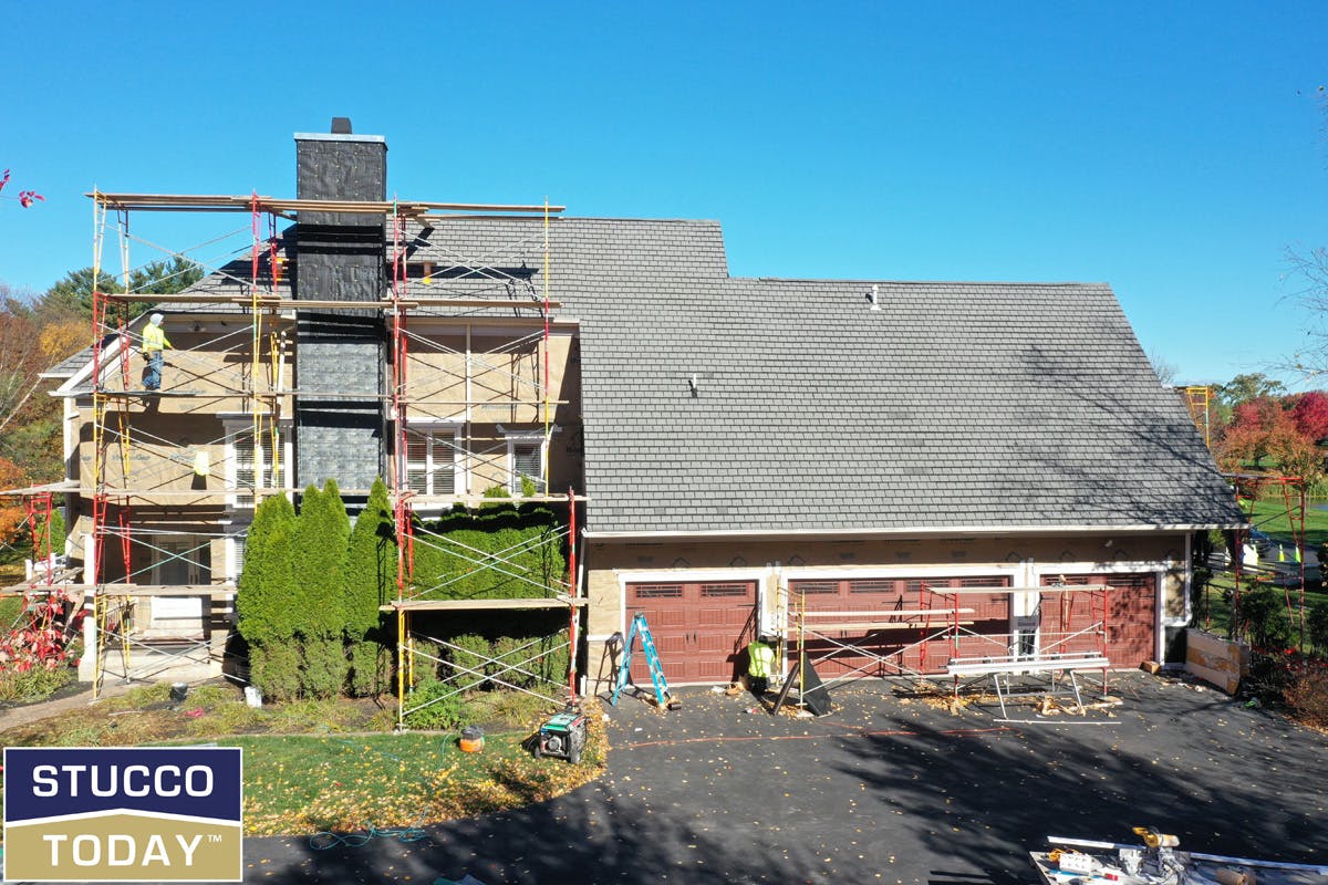 large suburban house with stucco remediation in progress