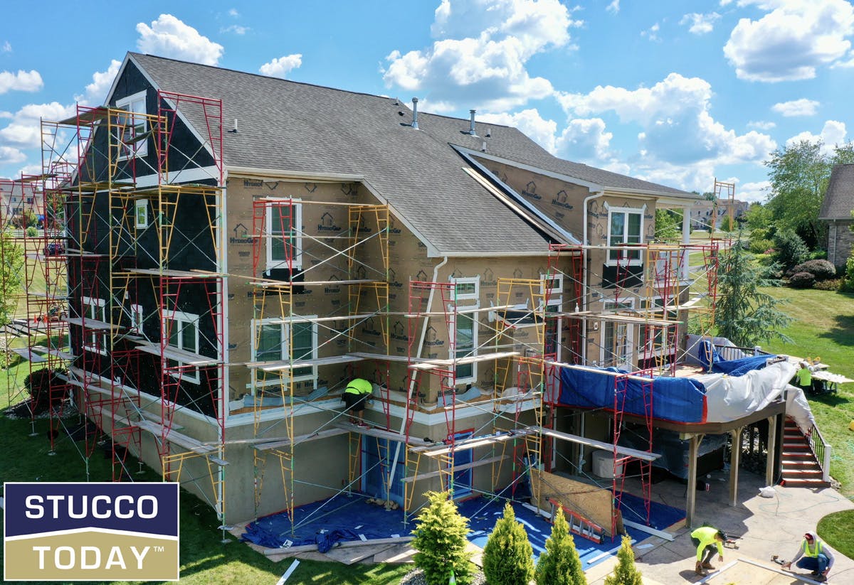 large suburban house with stucco remediation in progress