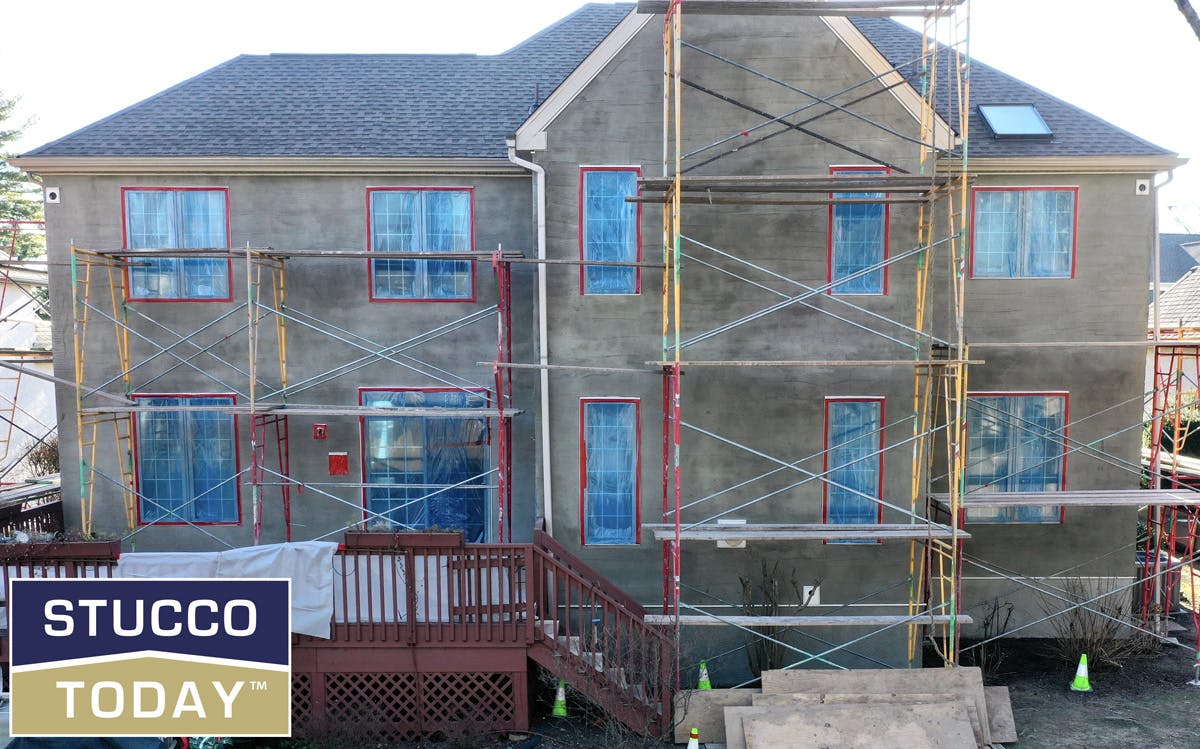 large suburban house with stucco remediation in progress