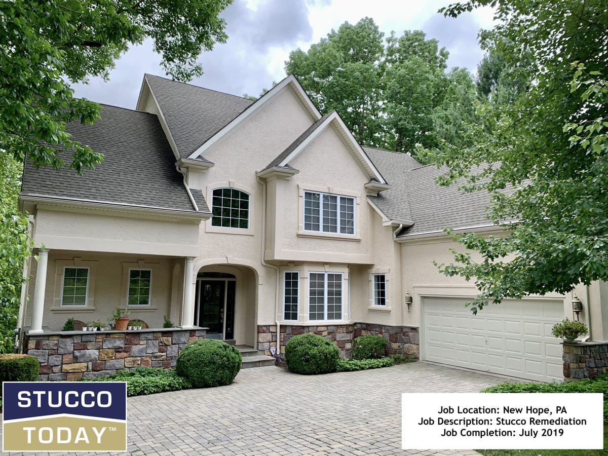 large suburban house with stucco remediation in progress