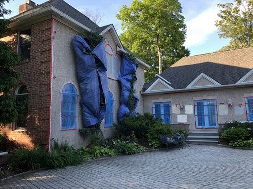 white suburban house with in progress stucco remediation