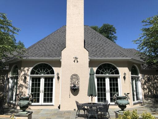 white suburban house with in progress stucco remediation