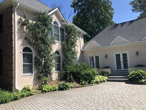 white suburban house with in progress stucco remediation