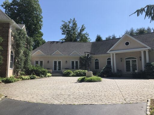 white suburban house with in progress stucco remediation