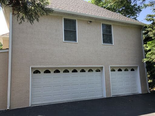 garage of white suburban house with completed stucco remediation