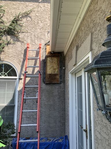 white suburban house with in progress stucco remediation