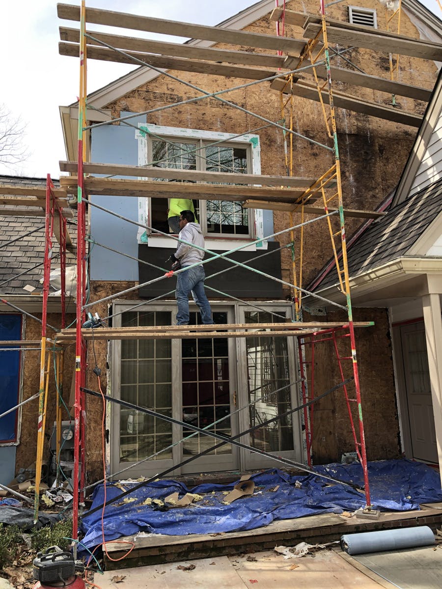 two story suburban house with in progress stucco remediation