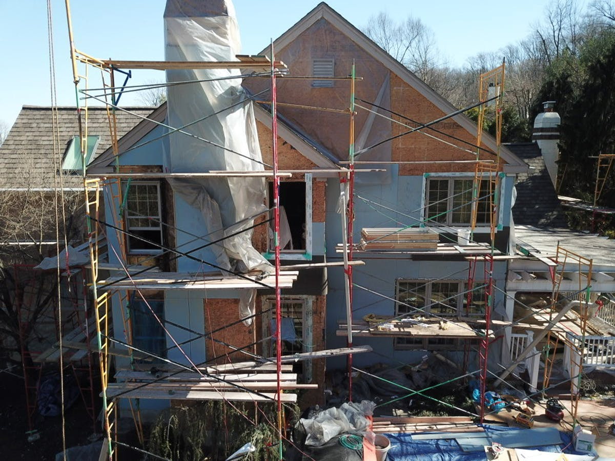 two story suburban house with in progress stucco remediation