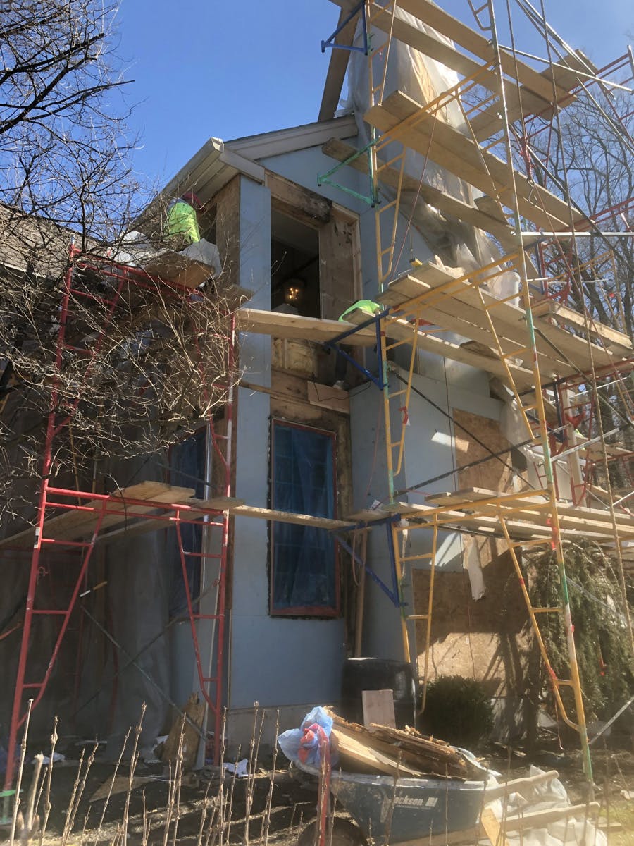 two story suburban house with in progress stucco remediation