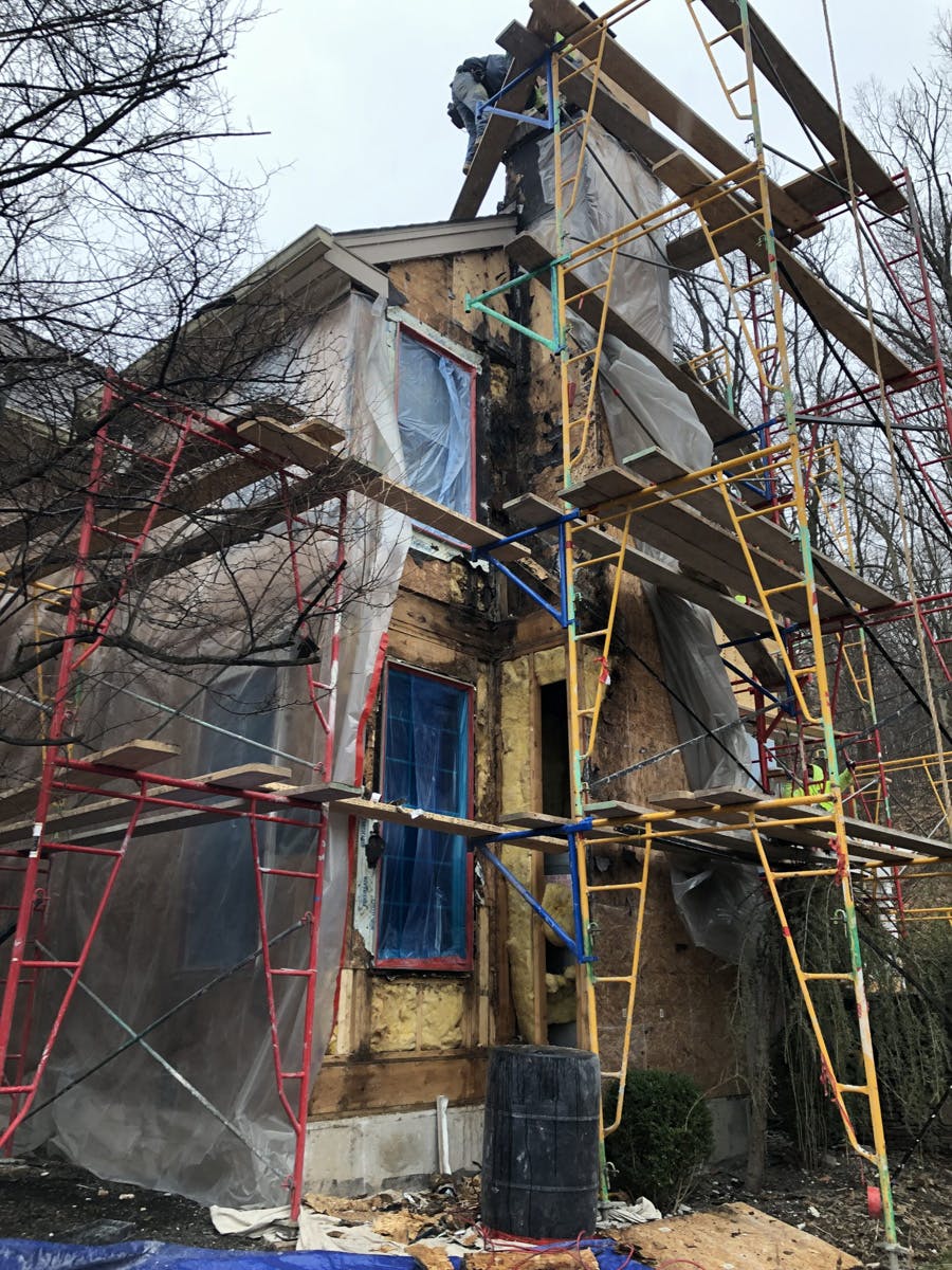 two story suburban house with in progress stucco remediation