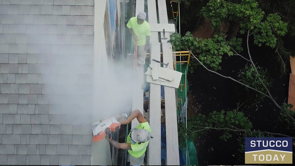 two guys working on stucco remediation for a large house in wester chester, pa