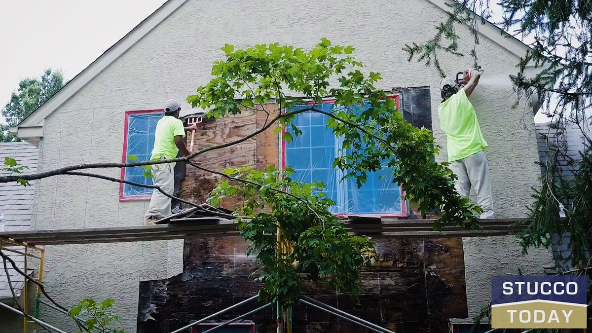 two guys working on stucco remediation for a large house in wester chester, pa