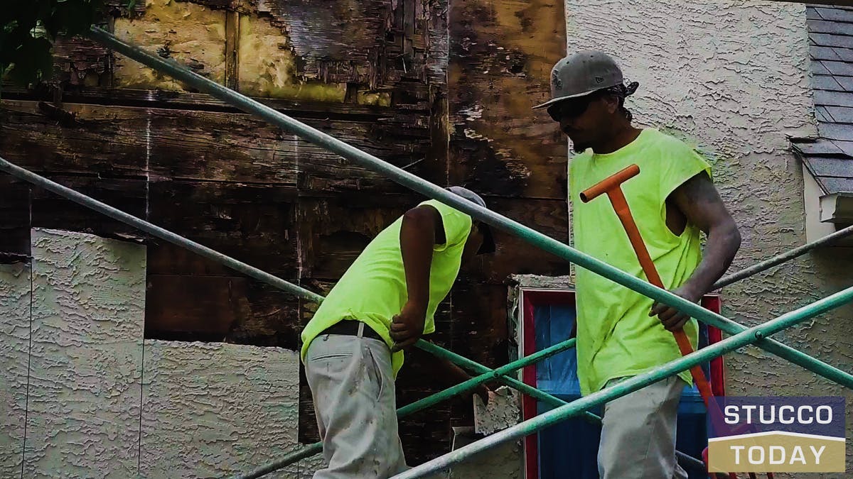 two guys working on stucco remediation for a large house in wester chester, pa