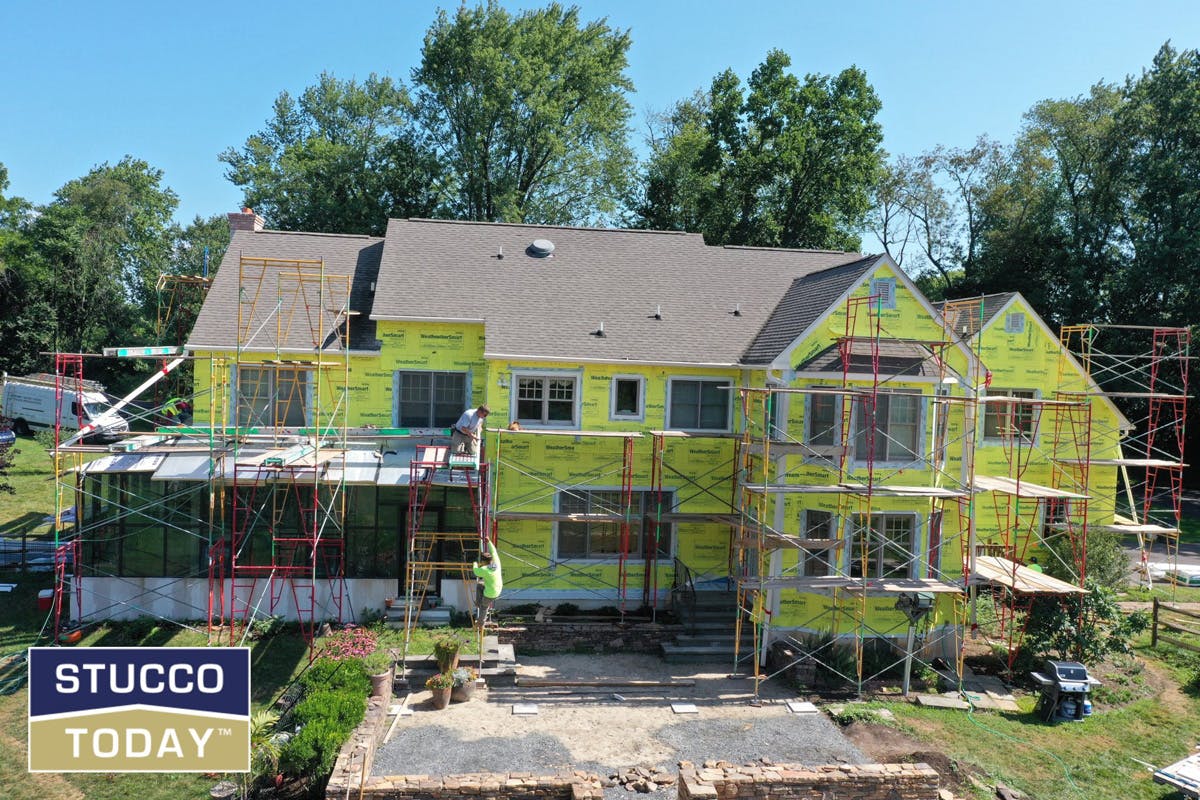 large suburban house with stucco remediation in progress