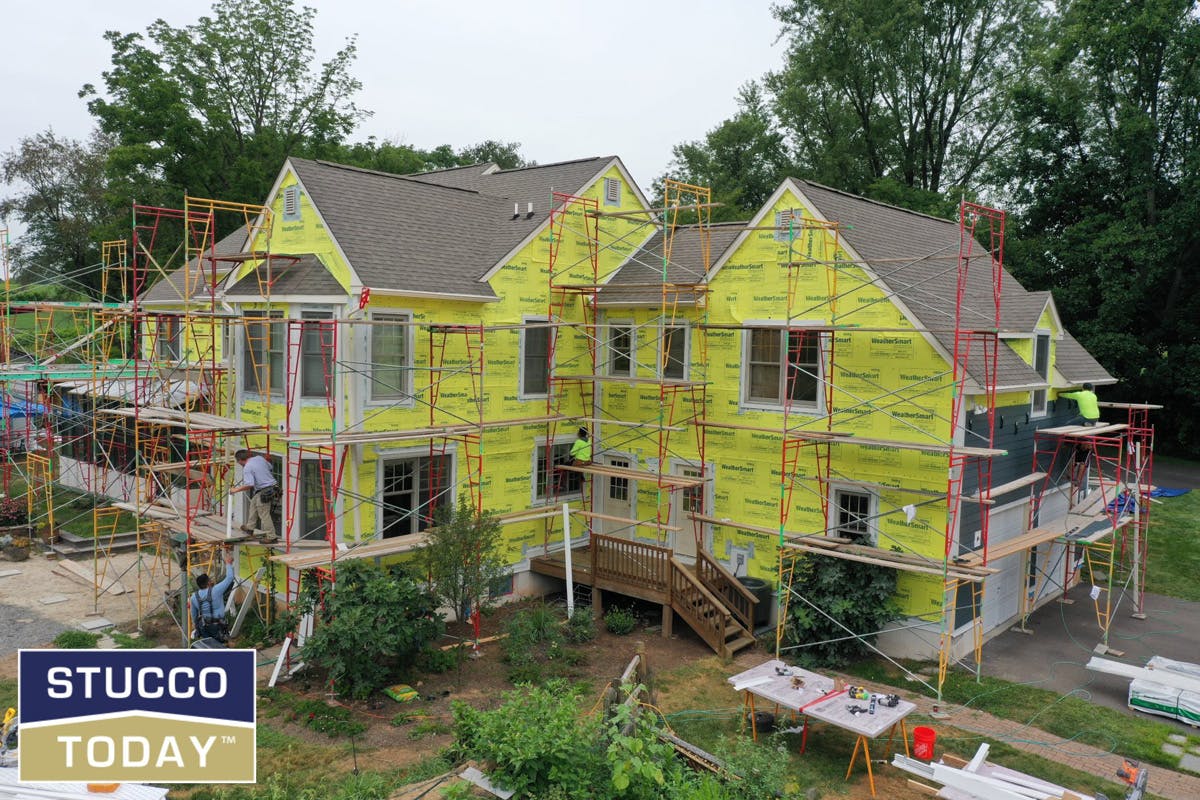 large suburban house with stucco remediation in progress